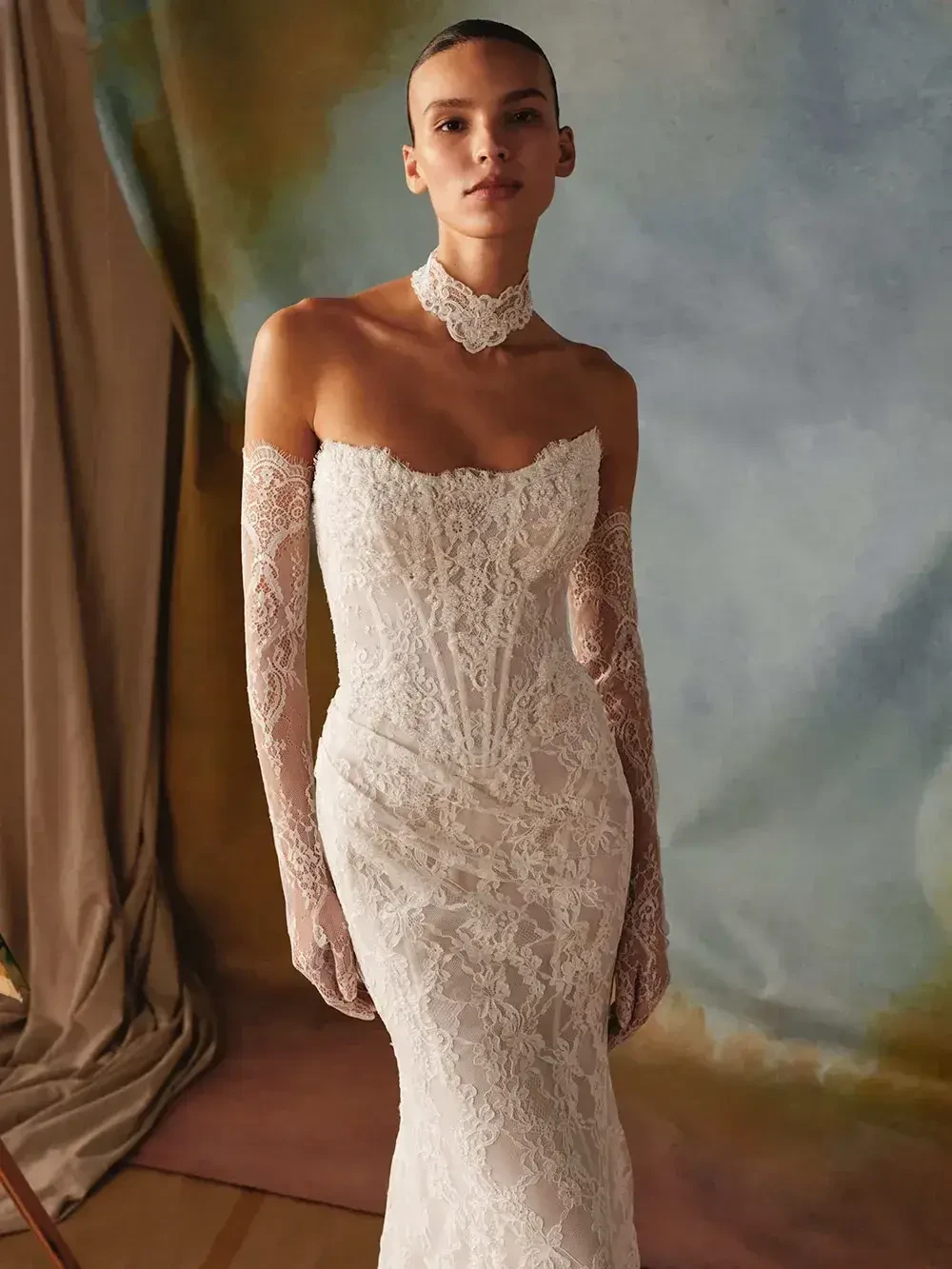 model is wearing a strapless lace bridal gown with detachable long sleeves