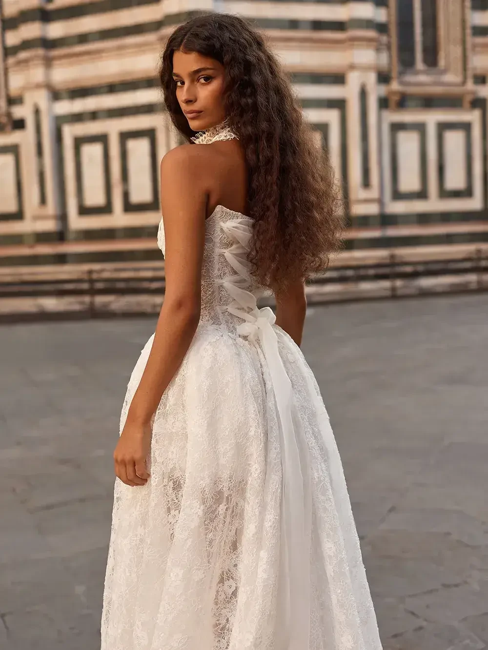 model is wearing an open back bridal gown