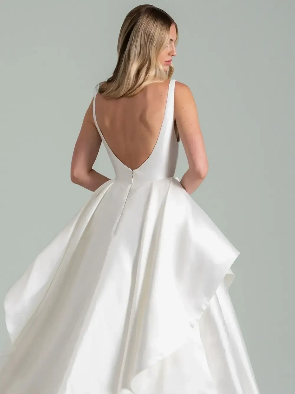 model is wearing an open back sleeveless a-line bridal gown