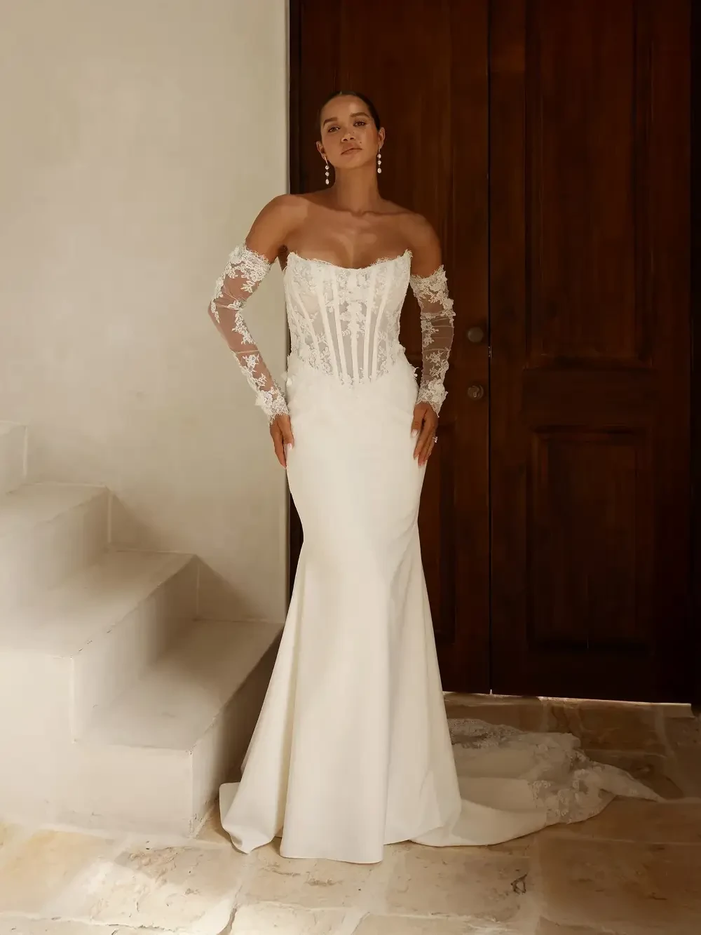 model is wearing a lace off the shoulder bridal gown