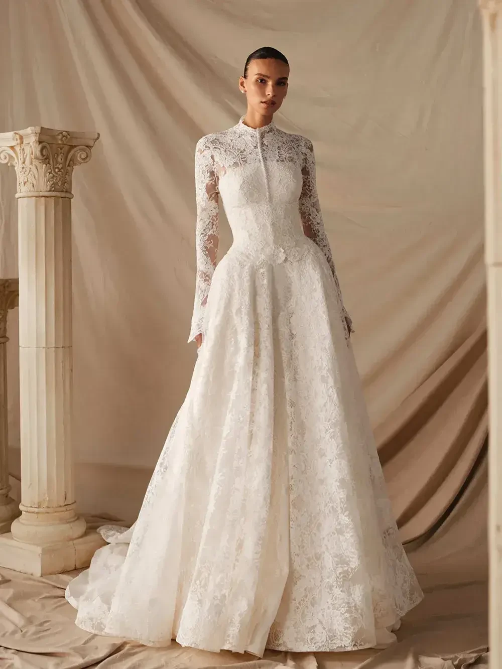 model is wearing a high neckline long sleeve lace bridal gown